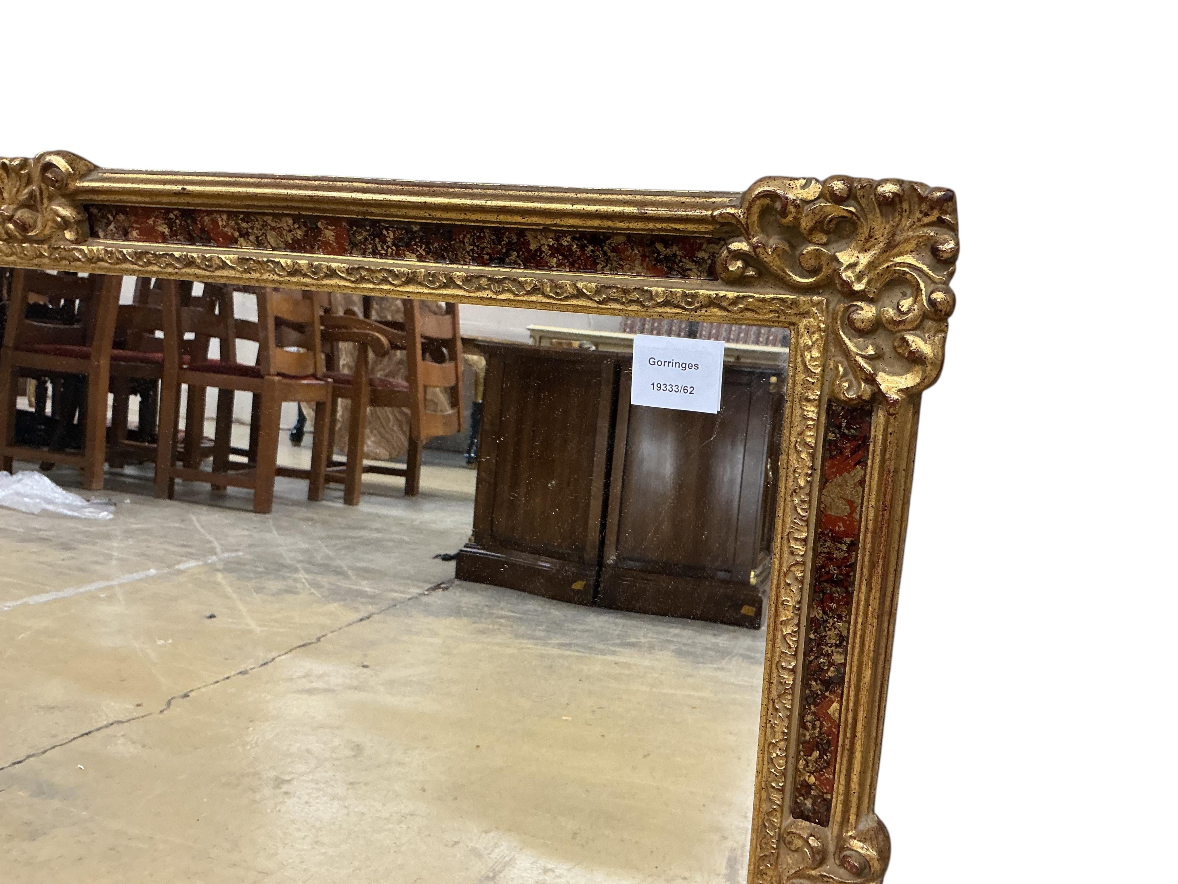 A Victorian style rectangular gilt composition wall mirror with decorated reverse glass slip, width 94cm, height 68cm